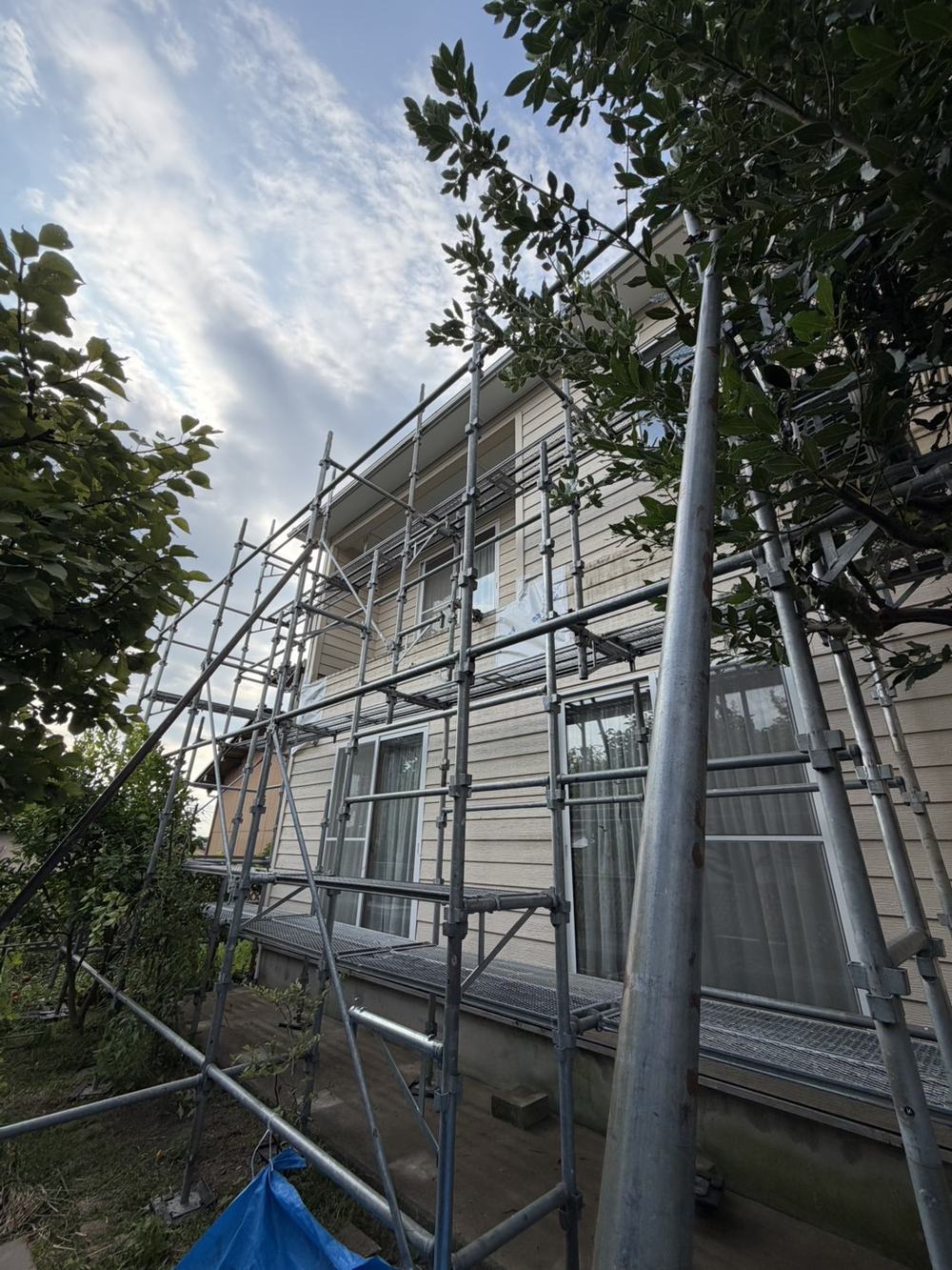 住宅の外壁に沿って組まれた足場と養生